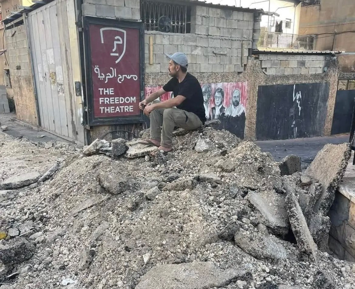Man sits on rubble Image Zoe Lafferty Twitter